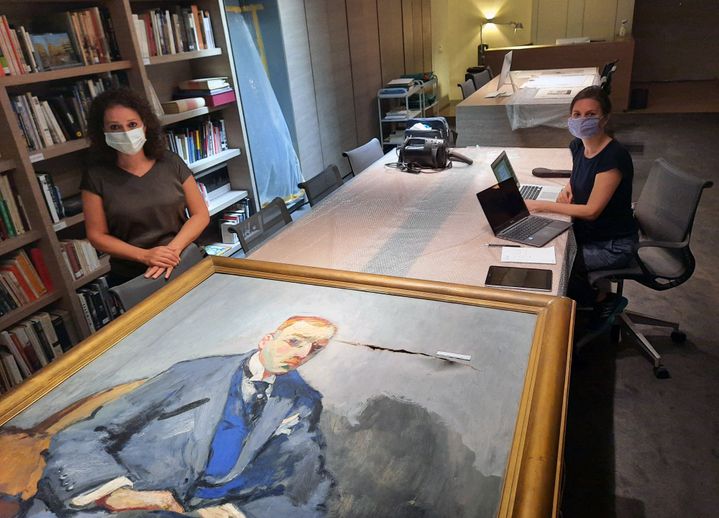 La directrice et une restauratrice du musée Sursock, dans le quartier d'Achrafieh, devant un portrait de Nicolas Sursock, déchiré par l'explosion qui a frappé Beyrouth le 4 août 2020. (AURÉLIEN COLLY / ESP - REDA INTERNATIONALE)