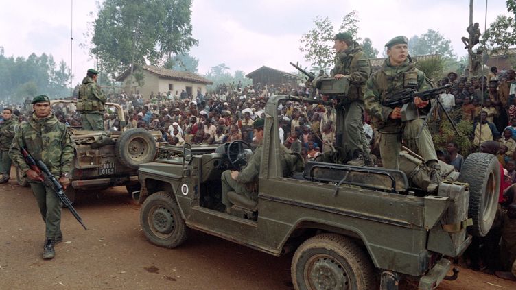 Des Hutus rwandais accueillent un détachement de marines français alors qu'ils traversent un camp de réfugiés à l'extérieur de Butare, le 3 juillet 1994. (HOCINE ZAOURAR / AFP)