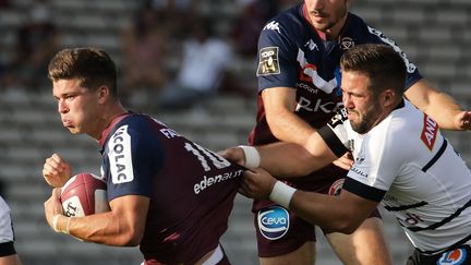 Matthieu Jalibert, l'international de l'UBB, repris par un Briviste (THIBAUD MORITZ / AFP)