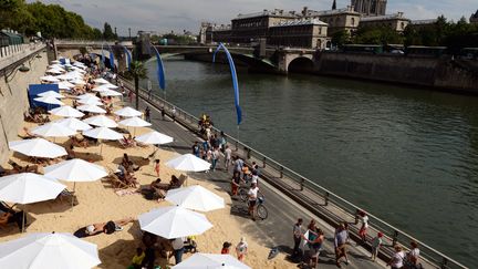 Des passants se prom&egrave;nent sur les quais de Seine,&nbsp;lors du troisi&egrave;me jour de l'op&eacute;ration "Paris plages", le 22 juillet 2015. (MIGUEL MEDINA / AFP)