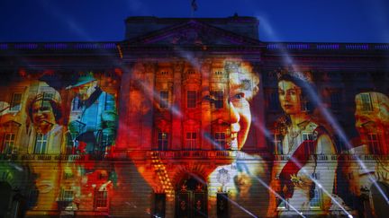 Des photos d'Elizabeth II projetées sur la façade de&nbsp;Buckingham Palace, à la fin du premier jour du jubilé de platine de la reine, à Londres, le 2 juin 2022. (DAVID CLIFF / AP)