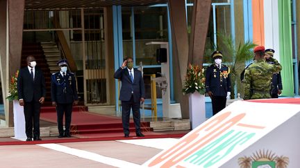 Le président ivoirien&nbsp;Alassane Ouattara (au centre), accompagné par le Premier ministre Hamed Bakayoko, lors d'une cérémonie marquant le&nbsp; 60e anniversaire de l'indépendance de la Côte d'Ivoire le 7 août 2020 au palais présidentiel, à Abidjan, la capitale ivoirienne. (SIA KAMBOU / AFP)