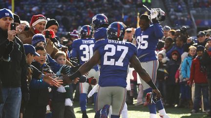 Les NY Giants à leur entrée sur le terrain entourés par les résidents de Newtown