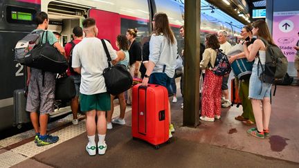 Des passagers s'apprêtent à embarquer dans un TGV en gare de Lyon Part-Dieu, le 14 août 2024. (MATTHIEU DELATY / AFP)