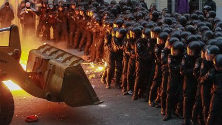 Des manifestants tentent de percer la barricade humaine form&eacute;e par des policiers devant le&nbsp;b&acirc;timent de l'administration pr&eacute;sidentielle &agrave; Kiev (Ukraine), le 1er d&eacute;cembre 2013. (GLEB GARANICH / REUTERS)