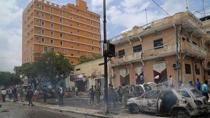 Les forces de sécurité somaliennes inspectent le site de l'explosion d'une voiture piégée, qui a fait 5 morts et une dizaines de blessés, à Mogadiscio, le 30 juillet 2017. (Sadak Mohamed/ANADOLU AGENCY/AFP)