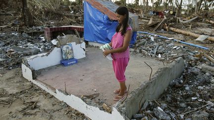 L'&eacute;pouse du maire du village de Hernani (Philippines) pose dans ce qu'il reste de son salon apr&egrave;s le passage du typhon Haiyan, le 18 novembre 2013. (WOLFGANG RATTAY / REUTERS)