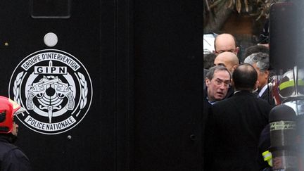 Le ministre de l'Int&eacute;rieur Claude Gu&eacute;ant patiente avec des policiers et des membres du GIPN pendant le si&egrave;ge de l'appartement de Mohamed Merah par le Raid &agrave; Toulouse (Haute-Garonne), le 22 mars 2012. (PHILIPPE DESMAZES / AFP)