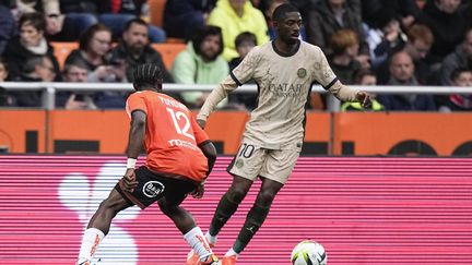 Le Parisien Ousmane Dembélé face à Darlin Yongwa de Lorient, lors du match Lorient-PSG de la 29e journée de Ligue 1, le 24 avril 2024 au stade du Moustoir de Lorient.  (MICHEL EULER/AP)