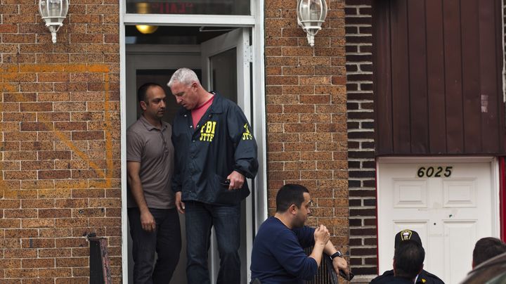 Un agent du FBI parle &agrave; un homme devant l'appartement d'Alina Tsarnaev, la soeur de Djokhar et Tamerlan Tsarnaev, &agrave; West New York, dans le New Jersey (Etats-Unis), le 19 avril 2013. (EDUARDO MUNOZ / REUTERS)