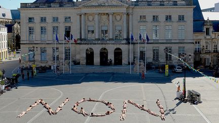 Les comédiens, artistes du cirque et techniciens de huit compagnies invitées durant le festival de cirque et de théâtre de rue de Châlons se sont dénudés et allongés sur le parvis de la mairie pour former avec leur corps le mot "non"
 (FRANCOIS NASCIMBENI / AFP)