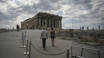 Des touristes se dirigent vers le site archéologique du Parthénon, sur la colline de l'Acropole à Athènes, où des travaux d'aménagement suscitent une polémique&nbsp;(4 juin 2021) (ARIS MESSINIS / AFP)