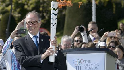 Le président du comité olympique brésilien, Carlos Arthur Nuzman, tout sourire, avec la flamme olympique dans les mains (ANTHONY ANEX/AP/SIPA / AP)