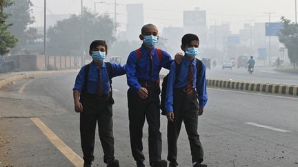 Des écoliers portent un masque pour se protéger de la pollution au smog, le 29 octobre dans les rues de Lahore au Pakistan. (ARIF ALI / AFP)