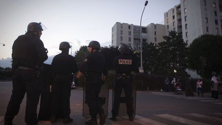 Des policiers stationnent dans la cit&eacute; des Tarter&ecirc;ts (Corbeil-Essonnes), le 6 juin 2011, au lendemain des &eacute;chauffourr&eacute;es durant lesquelles une fillette a &eacute;t&eacute; bless&eacute;e. (JOEL SAGET / AFP)