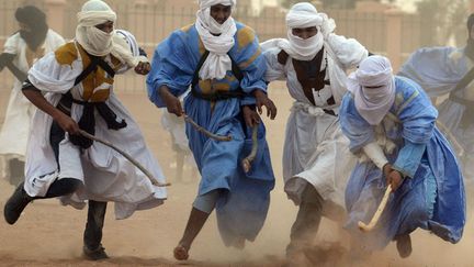 Des nomades jouent au hockey sur sable dans le d&eacute;sert marocain &agrave;&nbsp;M'hamid El Ghizlane, le 16 mars 2013. (FADEL SENNA / AFP)