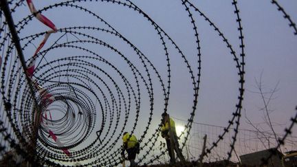 Pose d'une barrière entre l'Autriche et la Slovénie. Vienne tente de limiter l'arrivée de migrants sur son sol (9 décembre 2015). (JOE KLAMAR / AFP)