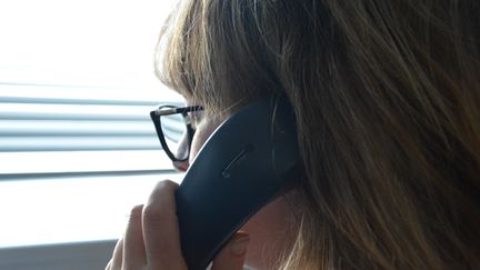 Une femme avec son combiné de téléphone fixe à l'oreille. (JEAN-CHRISTOPHE BOURDILLAT / RADIO FRANCE)