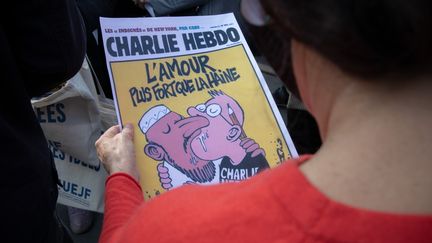 Une femme tient une couverture du journal "Charlie Hebdo", le 18 octobre 2020, à Paris. (EDOUARD MONFRAIS / HANS LUCAS)