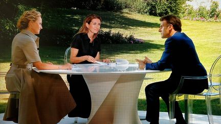 Emmanuel Macron répond aux questions des&nbsp;journalistes Caroline Roux et Anne-Claire Coudray dans les jardins de l'Elysée, le 14 juillet 2022. (LUDOVIC MARIN / AFP)