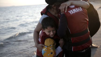 Comme la moiti&eacute; des migrants de m&eacute;diterran&eacute;e, cette famille a pris un bateau pour atteindre l'ile de Kos en Gr&egrave;ce le 18 ao&ucirc;t 2015. L'arriv&eacute;e en Union europ&eacute;enne est synonyme alors de bonheur. (? ALKIS KONSTANTINIDIS / REUTER / X03368)