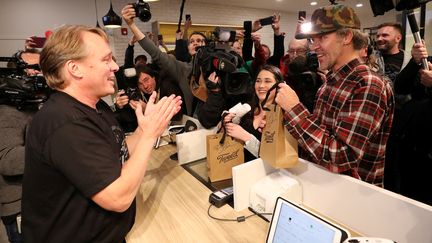 Le PDG de l'entreprise Canopy Growth, spécialisée dans la vente de cannabis, sert ses deux premiers clients, le 17 octobre 2018, à Saint-Jean-de-Terre-Neuve (Canada). (CHRIS WATTIE / REUTERS)