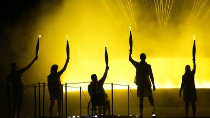 Charles-Antoine Kouakou, Elodie Lorandi, Fabien Lamirault, Alexis Hanquinquant et Nantenin Keïta ont eu l'honneur d'être les derniers porteurs de la flamme paralympique et ont allumé la vasque dans le jardin des Tuileries. (CHRISTOPHE ENA / SIPA)