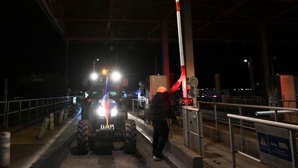 Un agriculteur français du syndicat CR 34 (Coordination rurale) conduit un tracteur, à un péage d'autoroute en route vers l'autoroute A9 en direction de la frontière espagnole à Béziers, dans le sud de la France, le 19 novembre 2024. (SYLVAIN THOMAS / AFP)