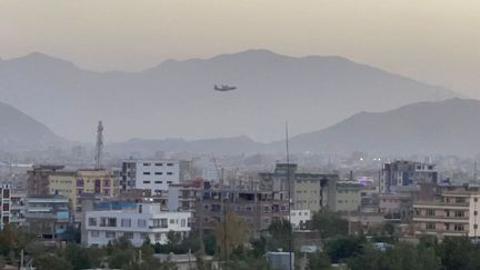 Un avion dans le ciel de Kaboul (Afghanistan), le 26 août 2021, après une double explosion près de l'aéroport. (HAROON SABAWOON / ANADOLU AGENCY / AFP)