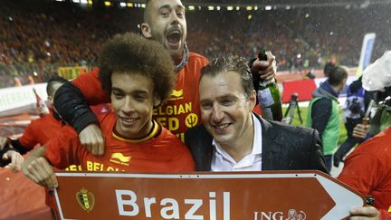 Le milieu belge Axel Witsel (G) et le s&eacute;lectionneur Marc Wilmots (D) f&ecirc;tent la qualification de l'&eacute;quipe pour la Coupe du monde au Br&eacute;sil, au Stade du Roi-Baudouin, &agrave; Bruxelles, le 15 octobre 2013.&nbsp; (FRANCOIS LENOIR / REUTERS)