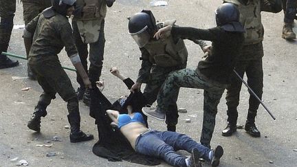 Des soldats &eacute;gyptiens passent &agrave; tabac une manifestante, pr&egrave;s de la place Tahrir, le 17 d&eacute;cembre 2011. (REUTERS)