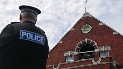Un policier, devant la mosquée de Southport (Royaume-Uni), attaquée par des émeutiers d'extrême droite, le 31 juillet 2024. (RASID NECATI ASLIM / ANADOLU / AFP)