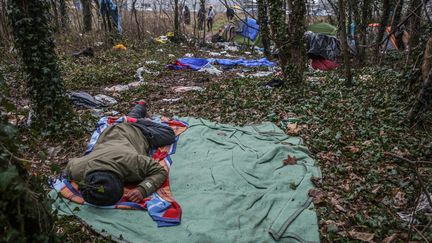 Atmosphère dans un camp improvisé de migrants dans la forêt de Calais, où certains dorment dehors sur de simples duvets au milieu des déchets. (MAXPPP)