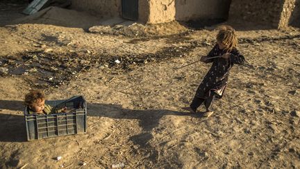 Deux jeunes fr&egrave;res dont la famille a fui les zones de conflit dans l'ouest du pays, s'amusent&nbsp;dans la banlieue d'Islamabad (Pakistan), le 19 novembre 2013. (ZOHRA BENSEMRA / REUTERS)