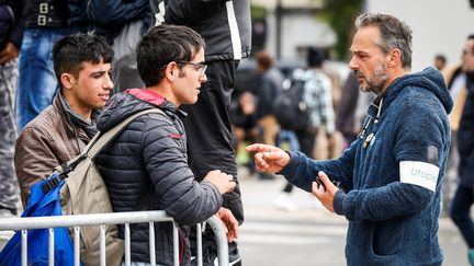 Yann Mazi (à droite), fondateur de l'association Utopia 56 en train de parler à un migrant, près de la porte de la Chapelle le 9 juin 2017. (GEOFFROY VAN DER HASSELT / AFP)