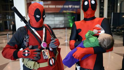 Deux participants d&eacute;guis&eacute;e attendent l'ouverture du Comic Con de New York (Etats-Unis), le 11 octobre 2012. (TIMOTHY A. CLARY / AFP)