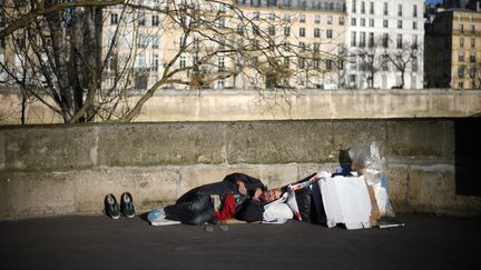 Un&nbsp;sans-abri sur un quai de l'île Saint-Louis, à Paris, en décembre 2017. (ERIC FEFERBERG / AFP)