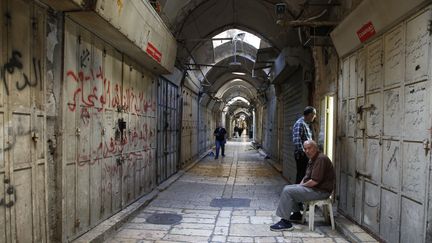 Dans la vieille ville, des habitants assis le 15 mai 2018 devant des magasins fermés lors de la grève générale en solidarité avec les Palestiniens tués la veille dans la bande de Gaza. (HAZEM BADER / AFP)