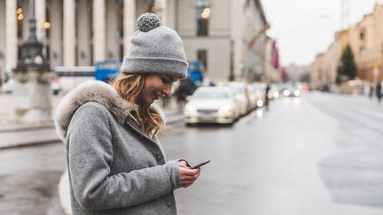 Photo d'illustration d'une femme possédant un smartphone dans la main, à Munich (Allemagne), le 12 décembre 2016. (WILLIAM PERUGINI / CULTURA CREATIVE)