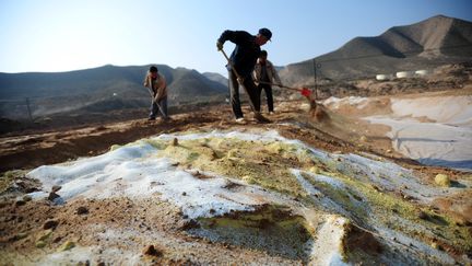 Des ouvriers nettoient un sol pollu&eacute;, dans la province de Gansu (nord-ouest de la Chine), en octobre 2011. (NIE JIANJIANG / XINHUA / AFP)