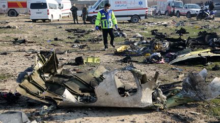 Un&nbsp;secouriste inspecte le site du crash d'un Boeing 737 ukrainien près de l'aéroport Khomeini de Téhéran, en Iran, le 8 janvier 2020. (FATEMEH BAHRAMI / ANADOLU AGENCY / AFP)