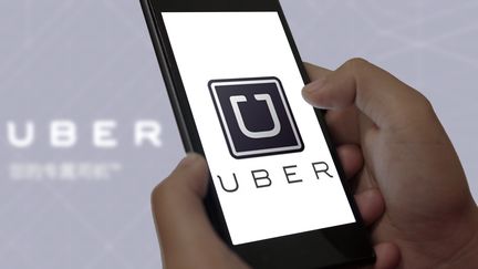 Un utilisateur de t&eacute;l&eacute;phone portable lan&ccedil;ant l'application Uber. (DA QING / IMAGINECHINA / AFP)