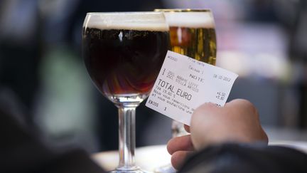 Un homme consulte l'addition apr&egrave;s avoir command&eacute; des bi&egrave;res dans un caf&eacute;, &agrave; Paris, le 4 octobre 2012. (LIONEL BONAVENTURE / AFP)