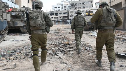 Israeli troops patrol a street during a military operation in the northern Gaza Strip, November 22, 2023. (AHIKAM SERI / AFP)