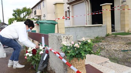 Une voisine dépose des fleurs devant la maison de Chahinez Daoud, le 5 mai 2021, au lendemain de la mort de cette femme brûlée vive&nbsp;par son mari, dont elle était en train de se séparer. (CLAUDE PETIT / MAXPPP)