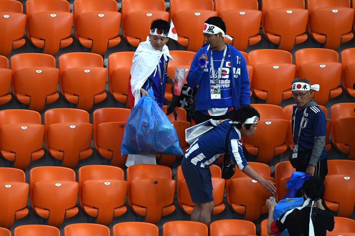 Les supporters du Japon ramassent les déchets à la fin du match opposant l'archipel au Sénégal lors des phases de groupe, lors du Mondial de football, en Russie en 2018. (ANNE-CHRISTINE POUJOULAT / AFP)