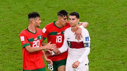 Les adieux d'une légende ? Après la défaite du Portugal en quarts de finale contre le Maroc (1-0), le 10 décembre 2022, Cristiano Ronaldo (37 ans) craque et se fait consoler par deux joueurs marocains. Les Lions de l'Atlas réalisent un exploit pour une nation africaine&nbsp;en se qualifiant pour le dernier carré, tandis que CR7 a peut-être joué son dernier match avec la Seleçao. (MARCIO MACHADO/SIPA)