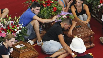 Des membres de la famille d'une des victimes tu&eacute;e dans l'accident d'autocar &agrave; Pozzuoli (Italie) pleurent sur son cercueil, le 30 juillet 2013. (CIRO LUCA / REUTERS)