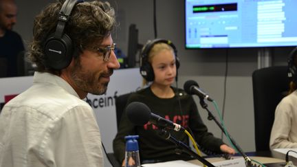 Le reporter Franck Mathevon, au micro des apprentis journalistes de franceinfo junior, dans un studio de Radio France. (E. Faure / franceinfo junior)