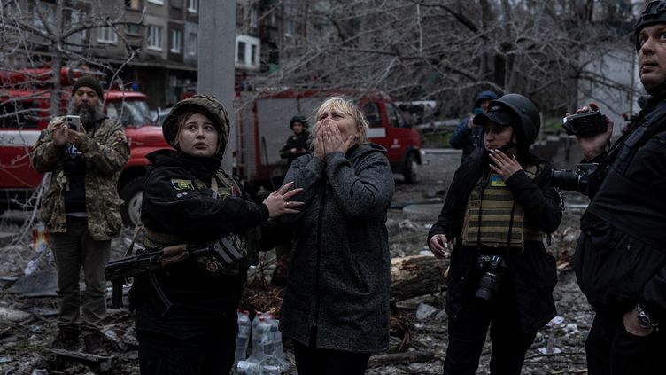 Une femme observe les dégâts d'un immeuble détruit par une frappe russe, le 14 avril 2023, à Sloviansk (Ukraine). (DIEGO HERRERA CARCEDO / ANADOLU AGENCY / AFP)